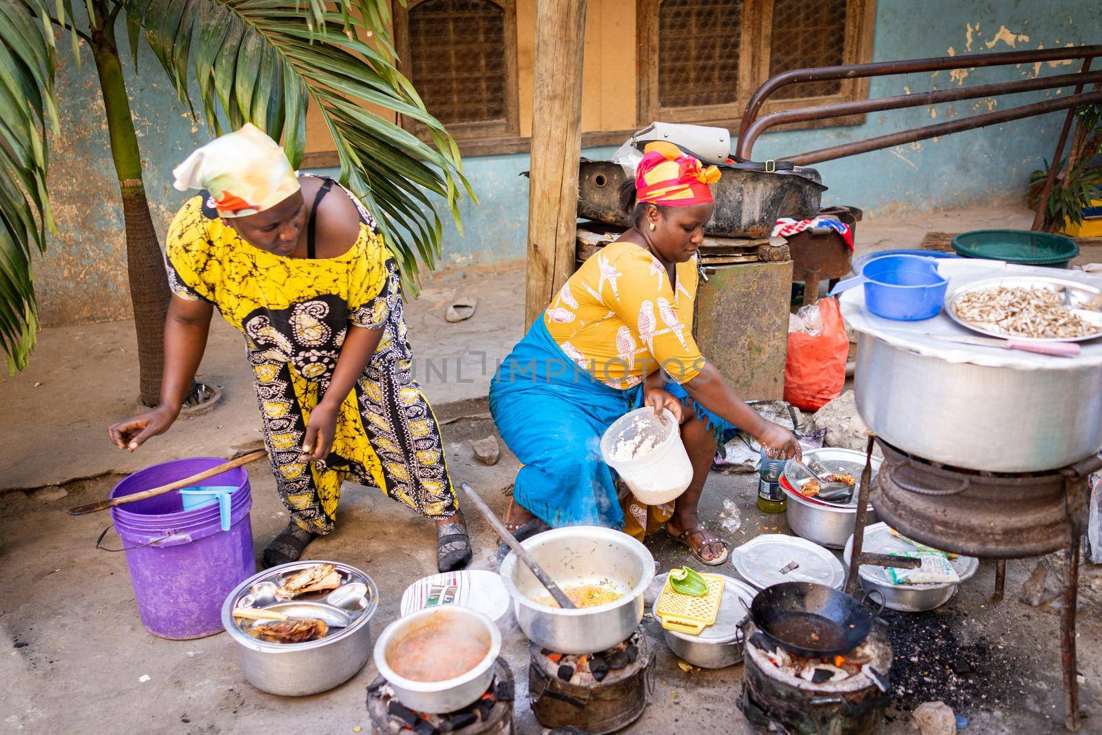 African woman cooking traditional food at street