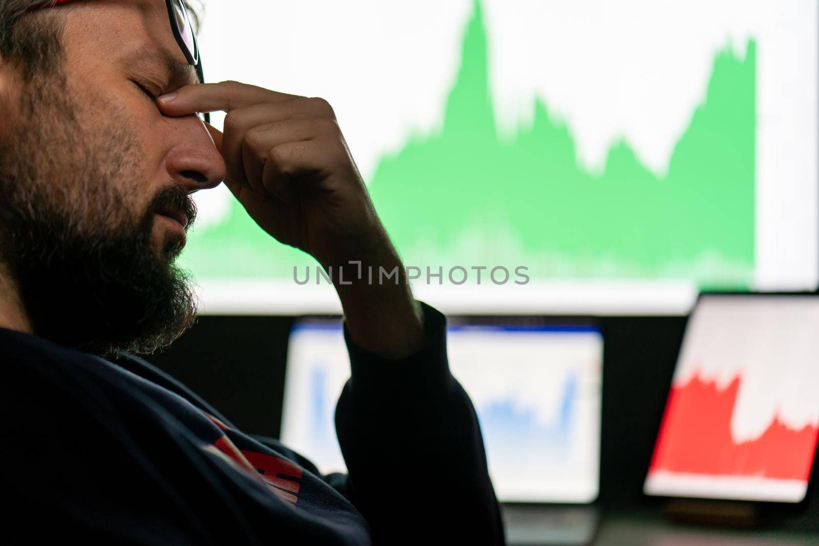 Depressed businessman in front of computer with graph of unsuccessful business on the screen. High quality photo.