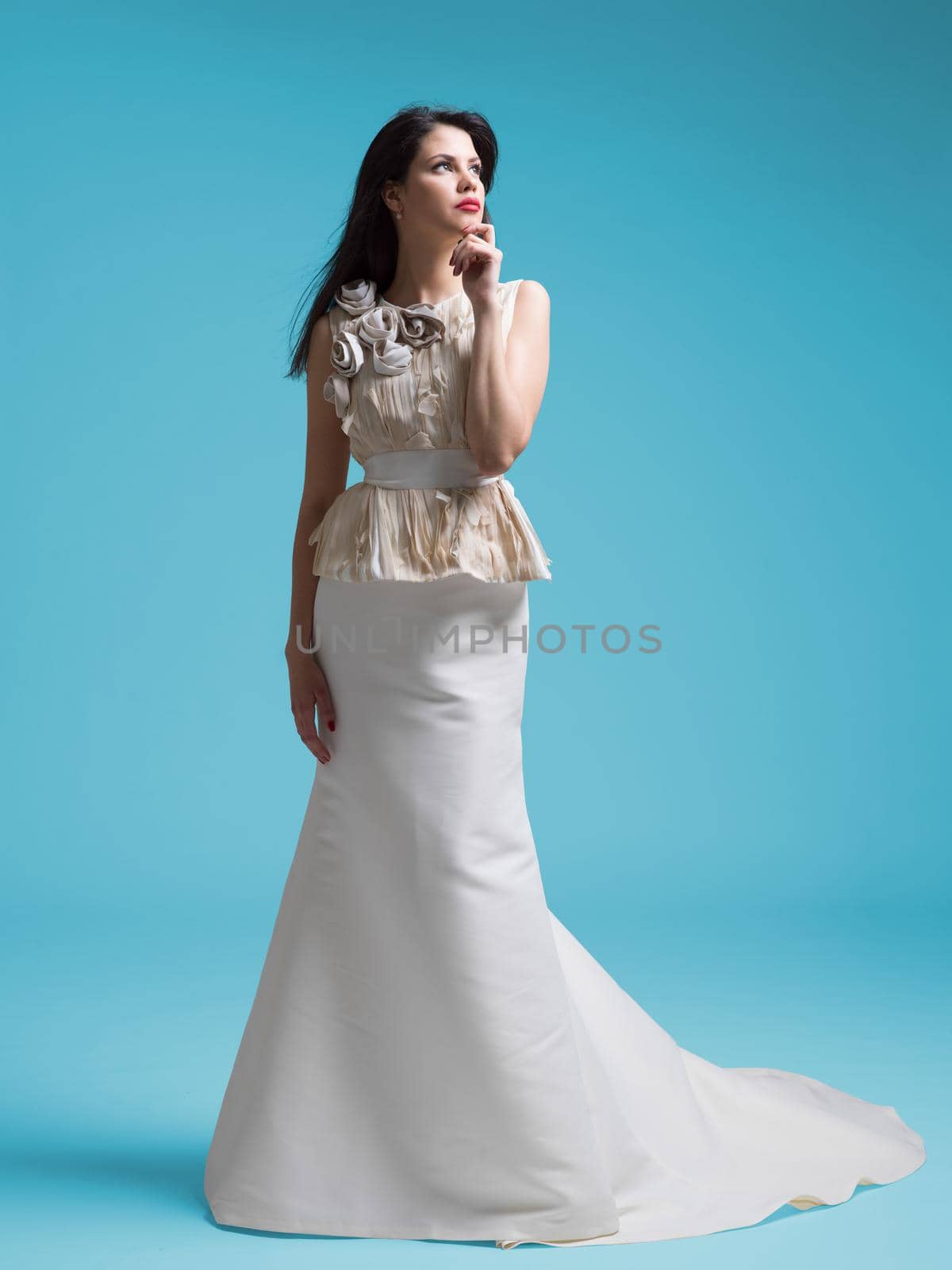 Portrait of beautiful young women in wedding dress isolated on a cyan background
