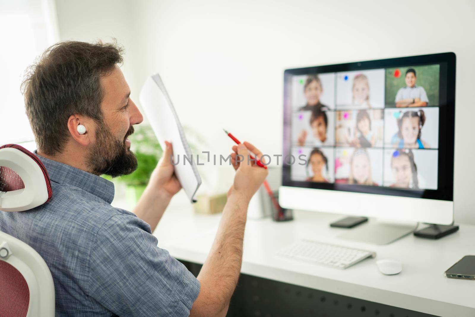 Male teacher having online conference with school children working at home