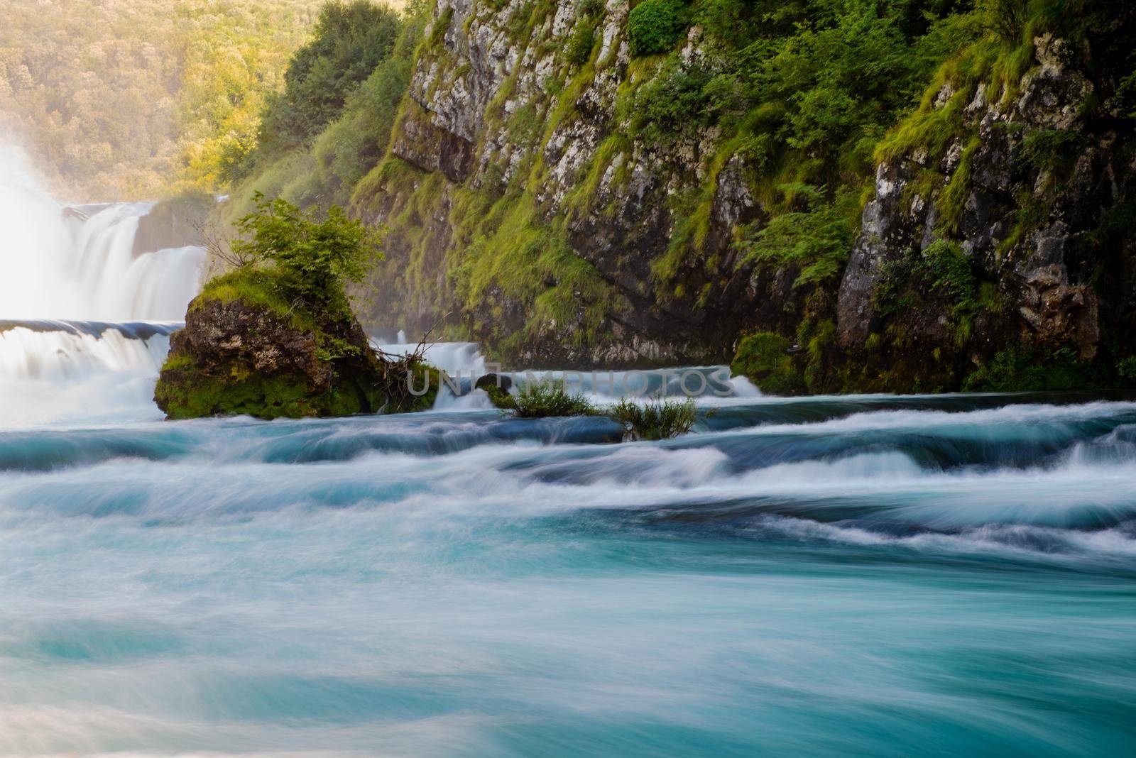 waterfall in beautiful nature with crystal clear water on wild river una in bosnia and herzegovina at sunny summer day