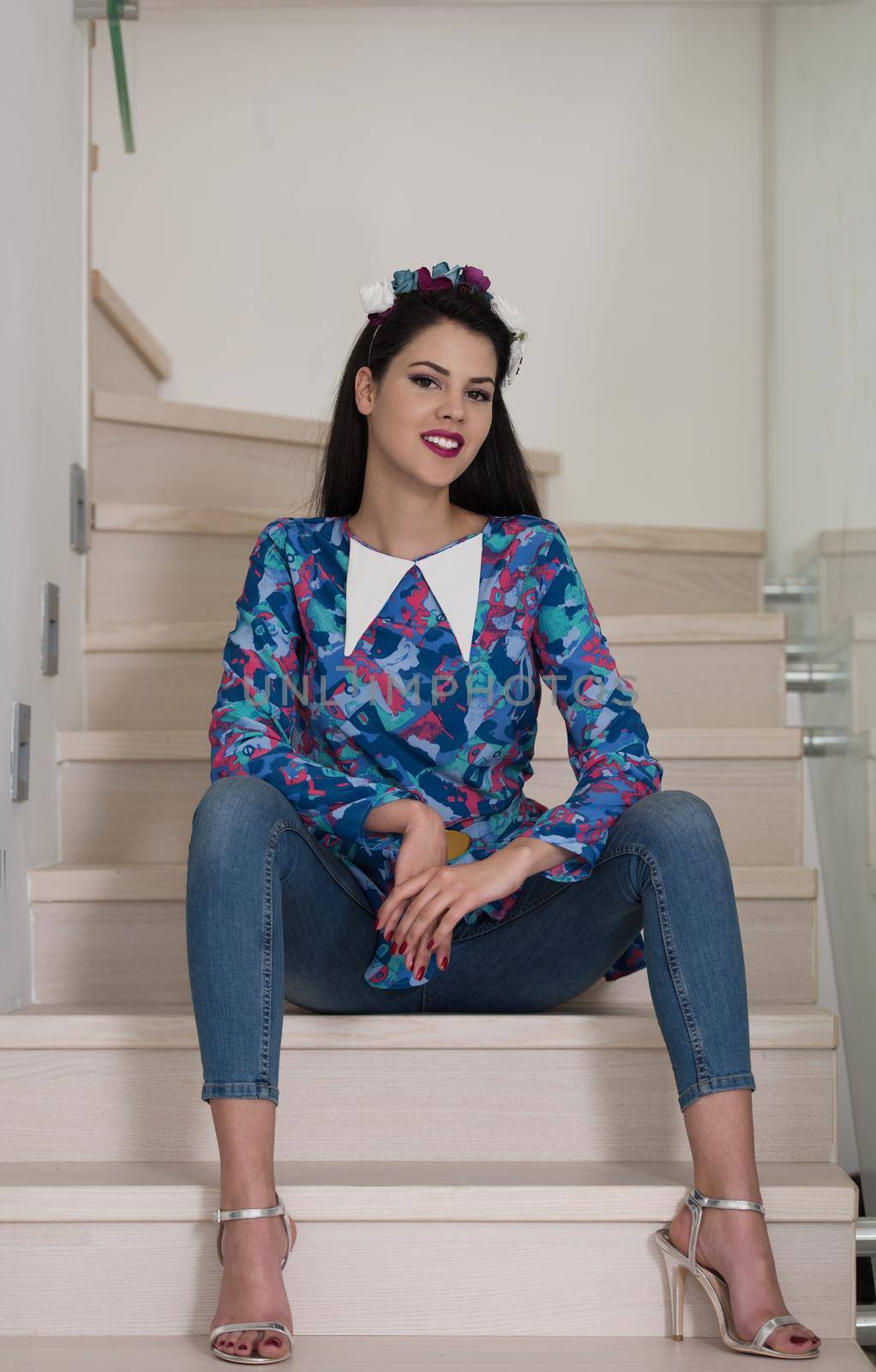 portrait of a young beautiful woman on the stairs in her luxurious home