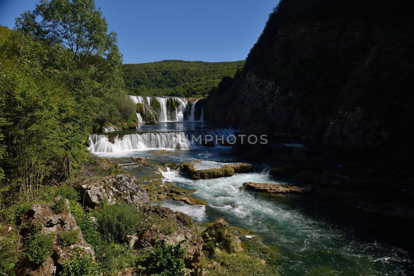 waterfall on wild river with fresh drinking water in summer