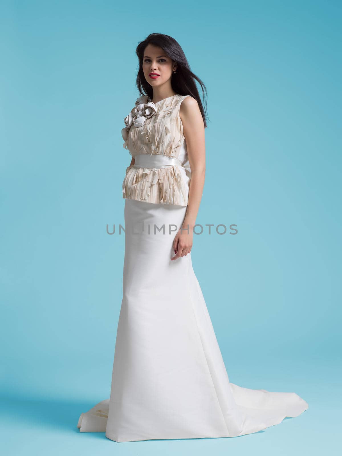 portrait of beautiful young woman as bride in wedding dress isolated on cyan backgrond in studio