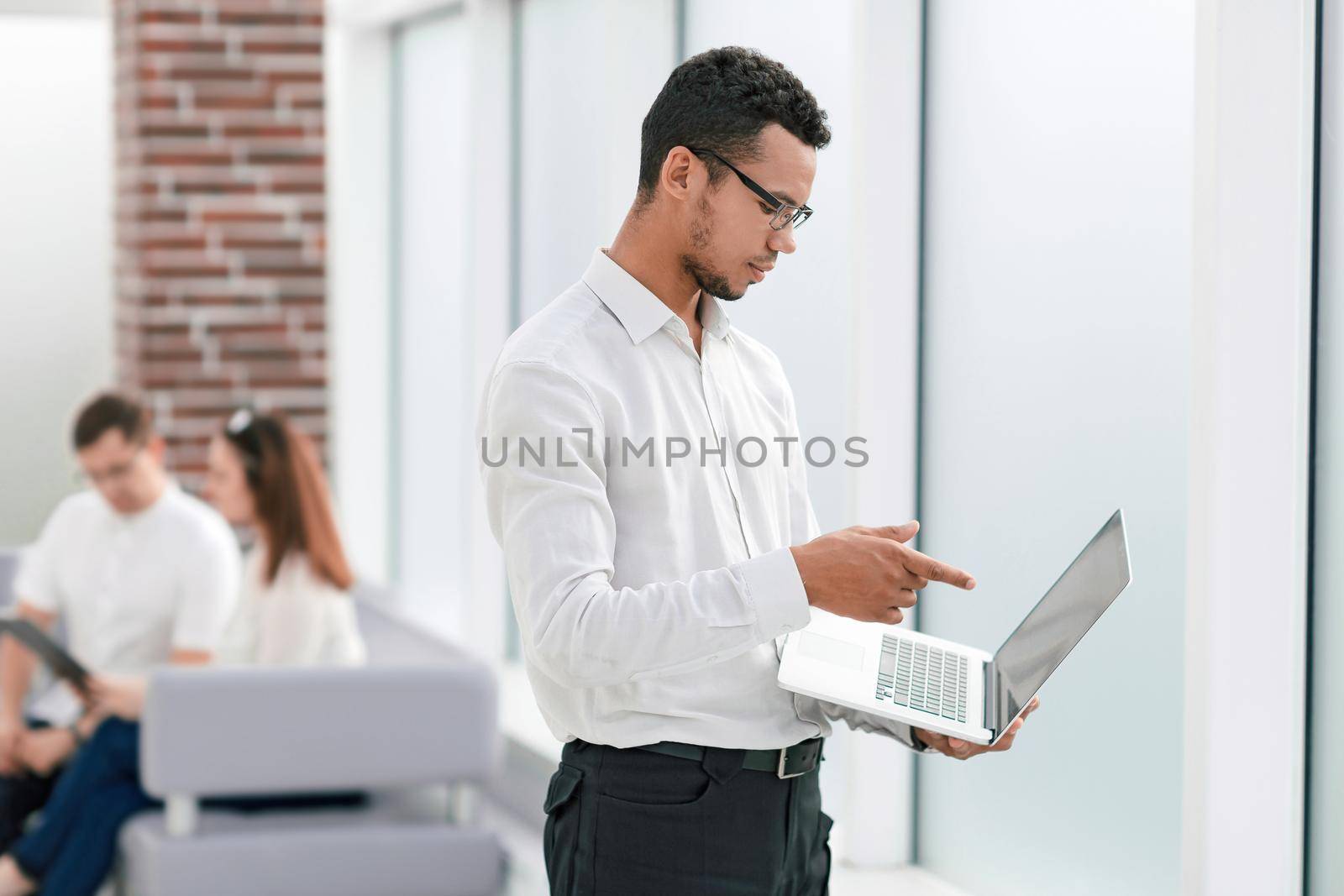 employee typing on a laptop standing in the office. people and technology