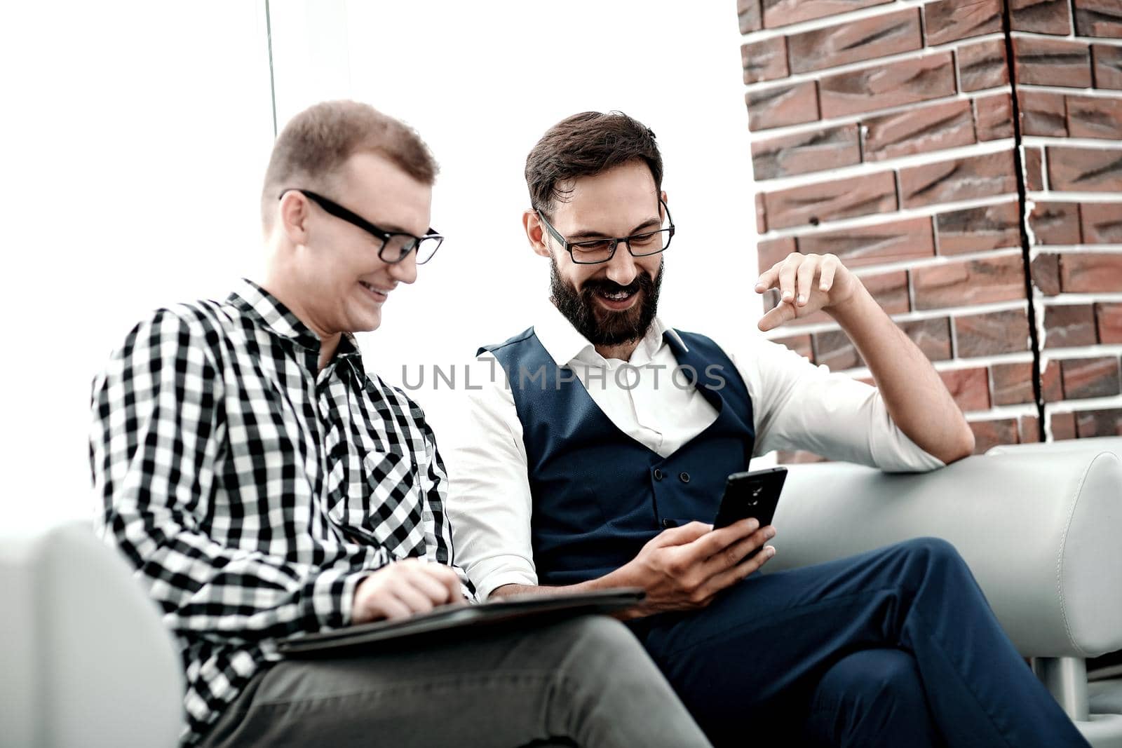 Two business people partners watching media content on a smartphone. .people and technology