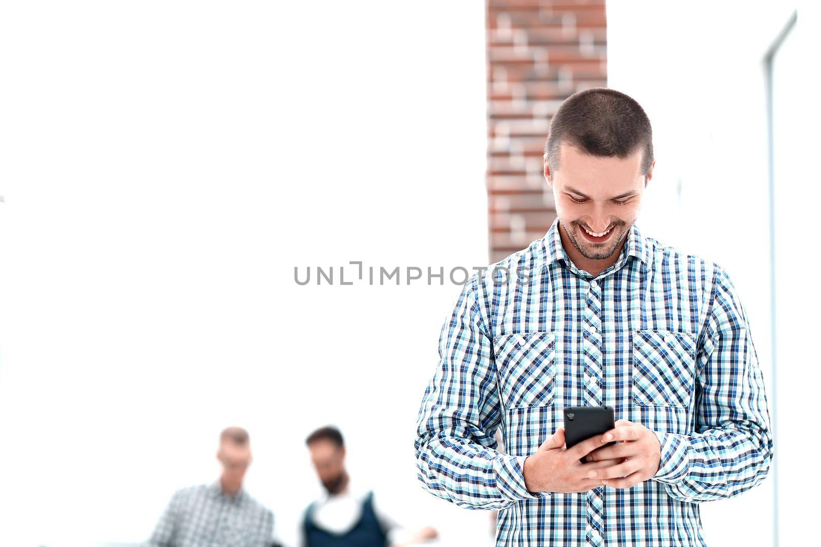 young man reading a SMS on his smartphone by SmartPhotoLab