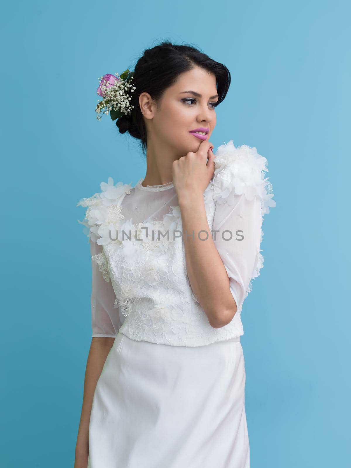 Portrait of beautiful young women in wedding dress isolated on a cyan background