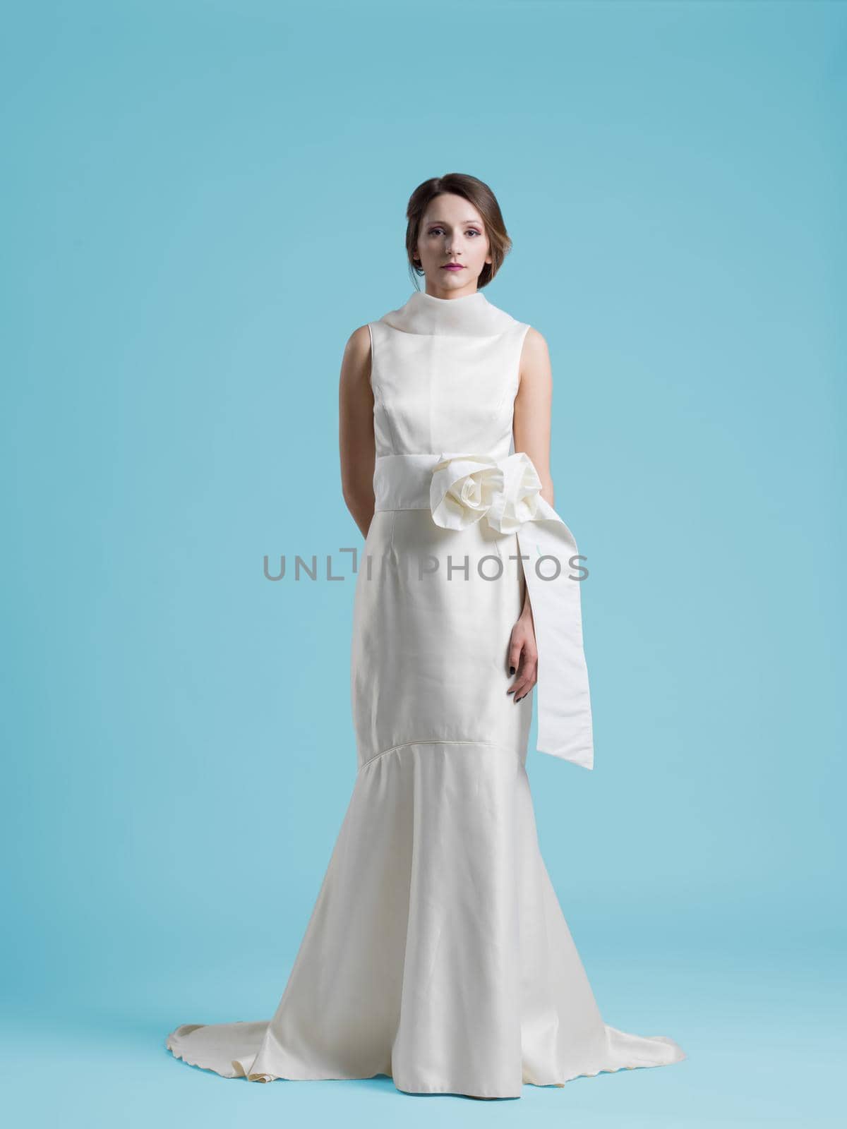 beautiful woman wearing wedding dress against cyan background by dotshock