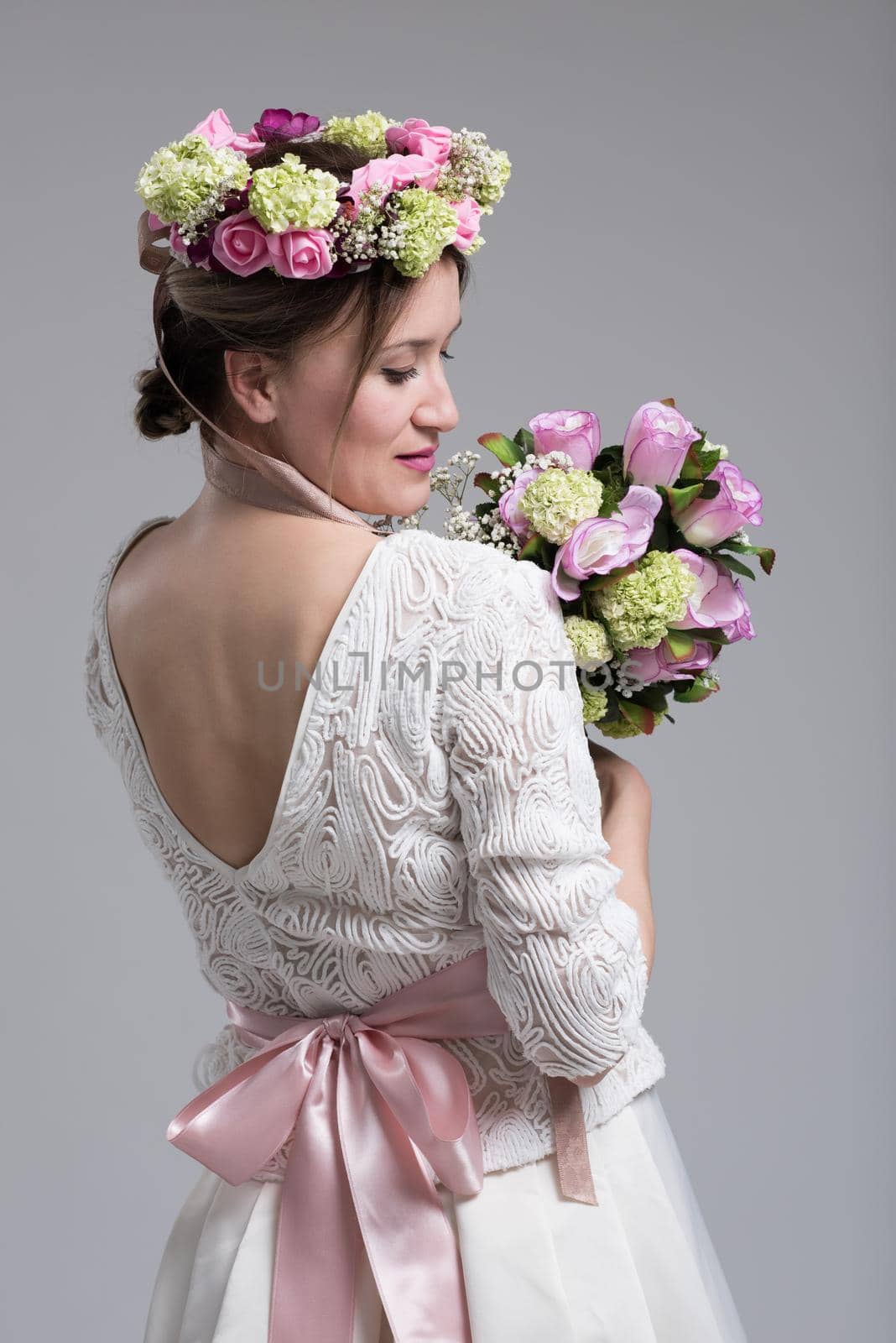 Young attractive bride with the a bouquet of flowers isolated on white background.