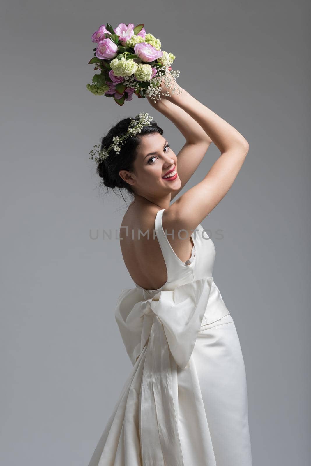 Young attractive bride with the a bouquet of flowers isolated on white background.