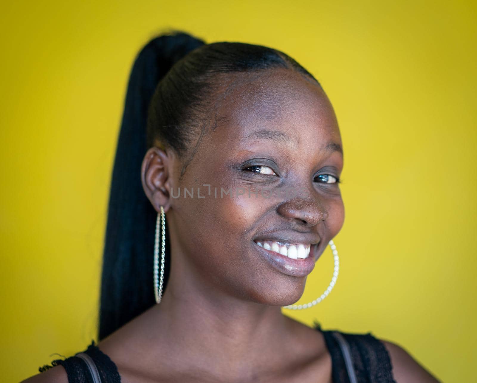 Beautiful dark skin young woman portrait on yellow