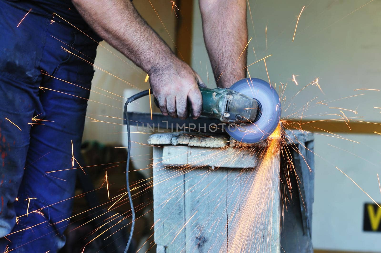 industry worker cut steel with spinning machine and spark