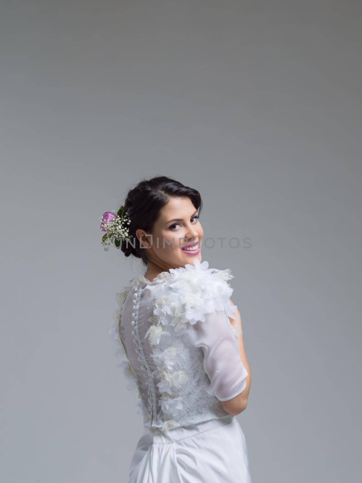 Rear view of a beautiful young bride in a wedding dress isolated on a white background