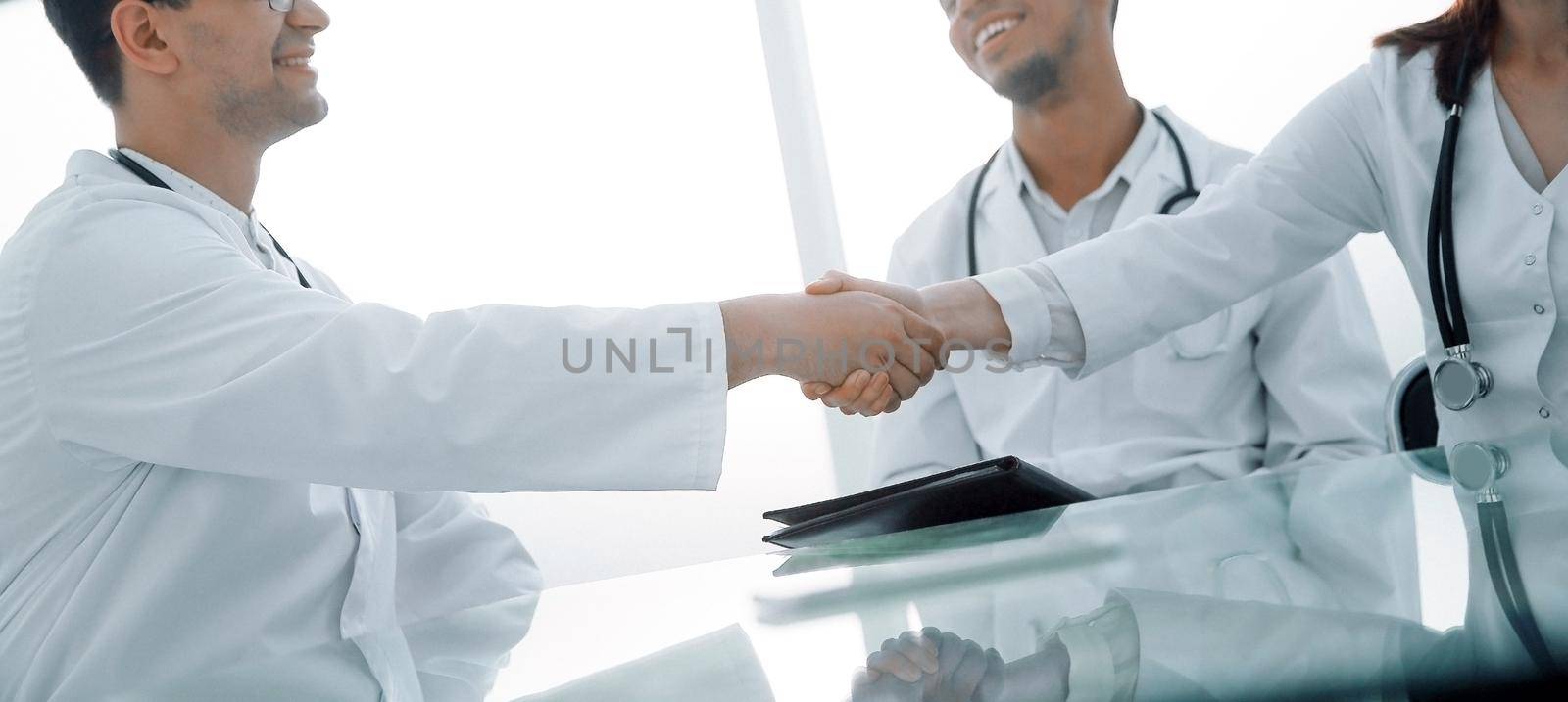 handshake of medical colleagues at a meeting at the hospital by SmartPhotoLab