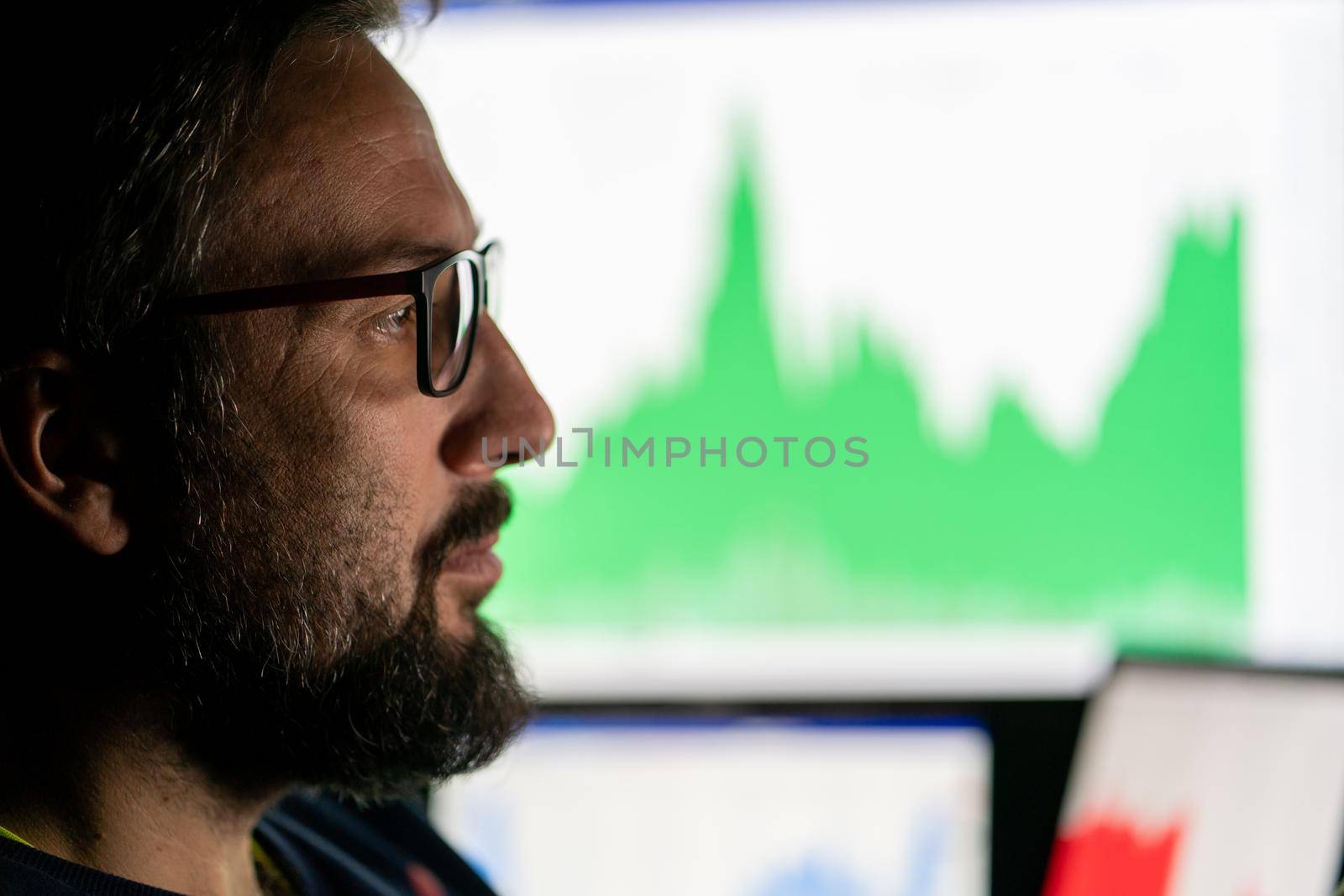 Crypto trader investor analyst looking at computer screen analyzing financial graph data on pc monitor, thinking of online stock exchange .