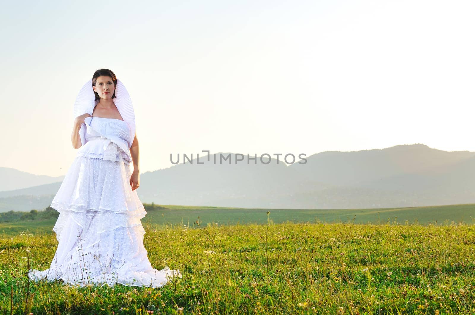 happy young beautiful bride after wedding ceremony event have fun on meadow in fashionable wedding dress