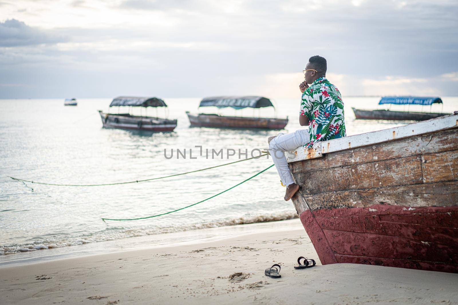 Young black man sitting on boat taking selfie alone