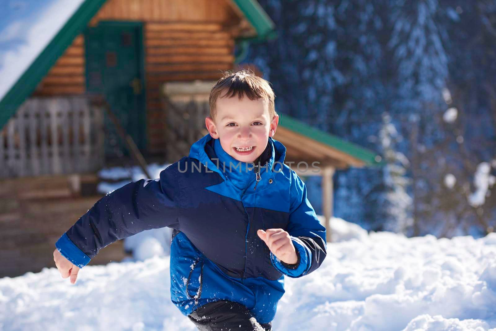 happy kids playing in fresh snow at beautiful  sunny winter day