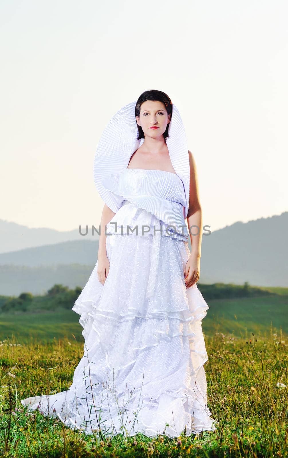 happy young beautiful bride after wedding ceremony event have fun on meadow in fashionable wedding dress