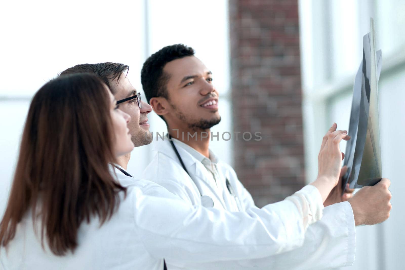 group of doctors discussing the patient's x-ray after surgery . the concept of health