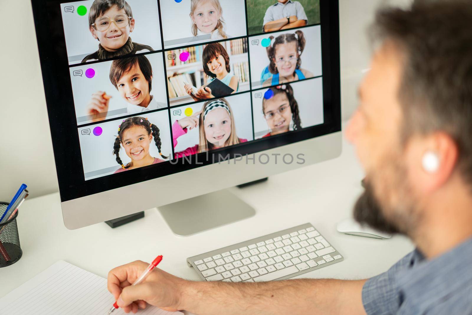 Male teacher having online conference with school children working at home