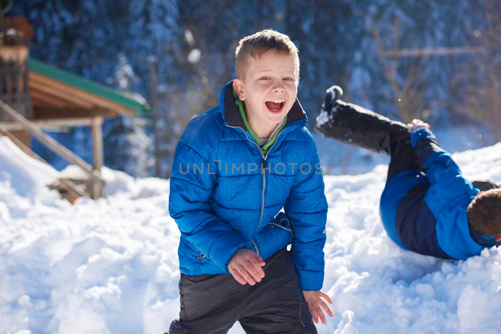 happy kids playing in fresh snow at beautiful  sunny winter day