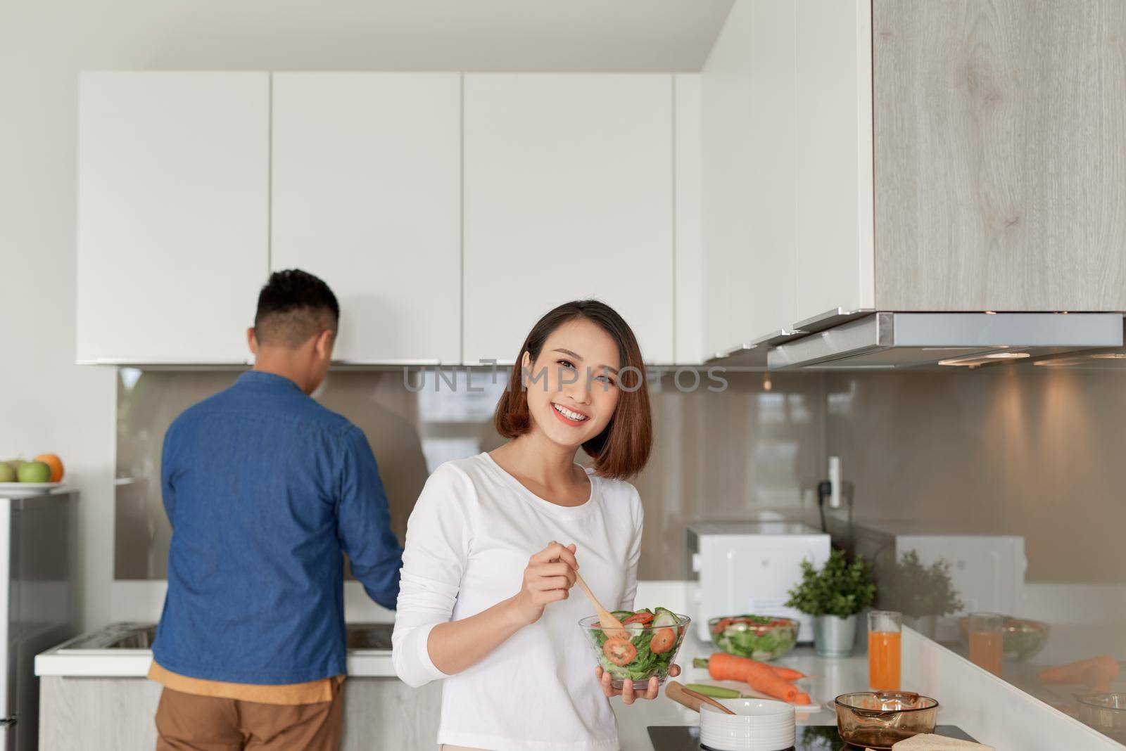 Smiling young couple cooking food in the kitchen