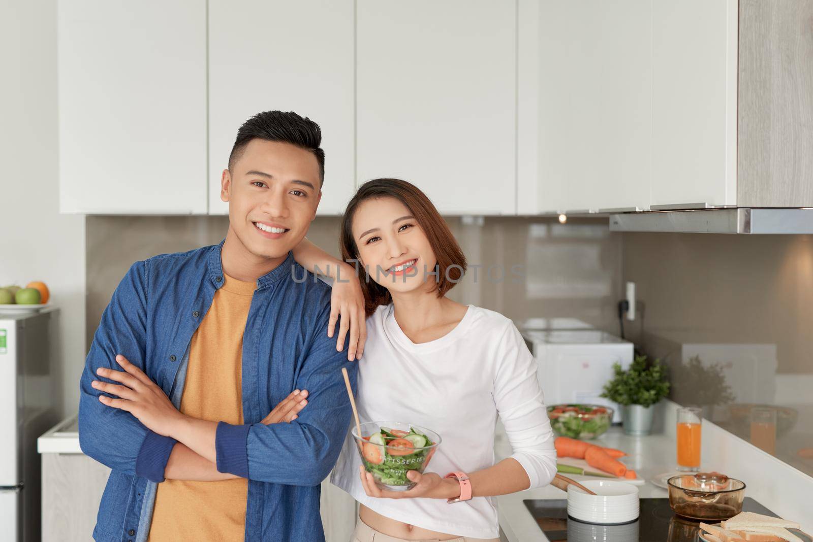 Happy smiling family couple cooking on loft kitchen. by makidotvn