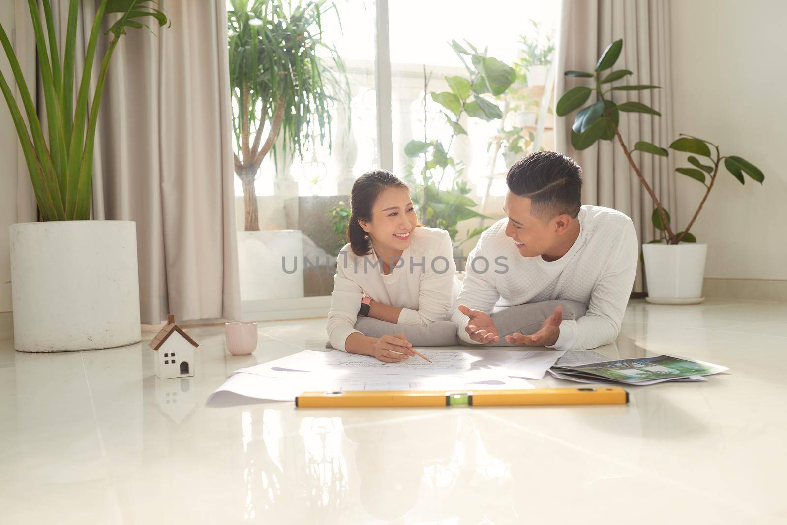 Man and woman looking at their house plans sitting in their new house