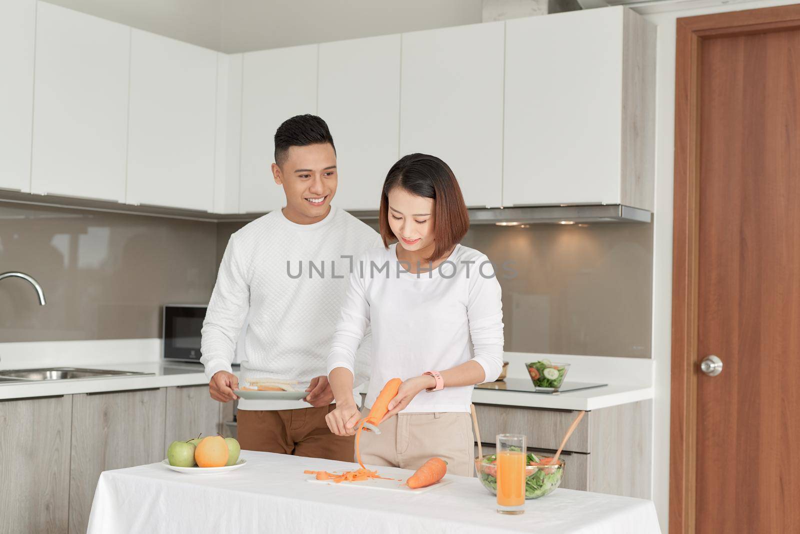 Happy smiling family couple cooking on loft kitchen.