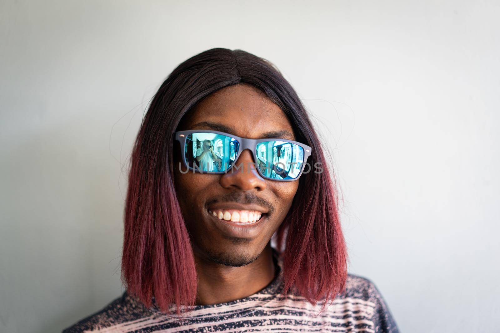 Funny black boy with long hair and sunglasses laughing