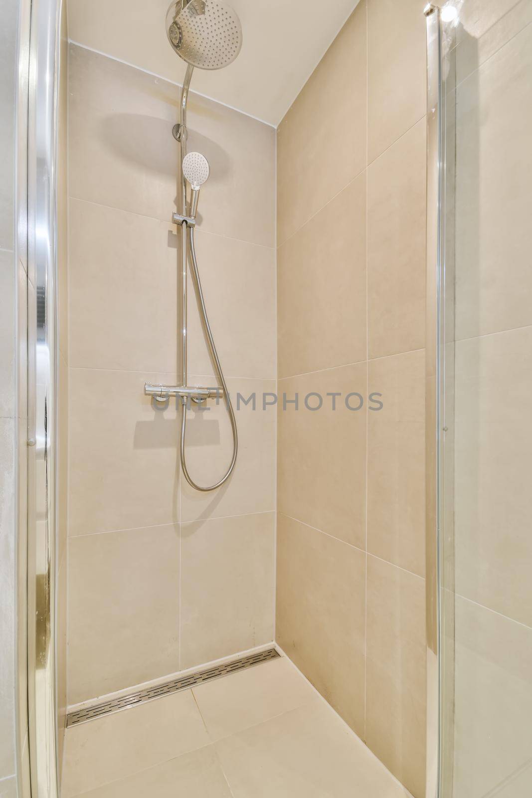 Spacious beige bathroom with shower cabin by casamedia
