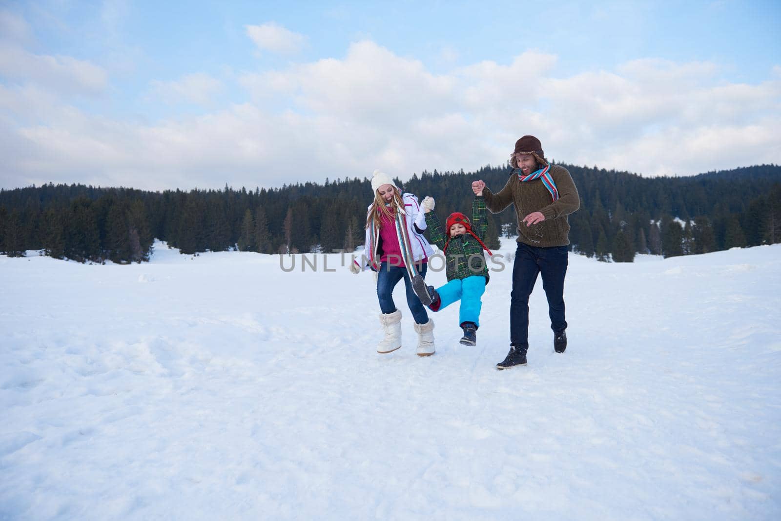 happy young  family playing in fresh snow  at beautiful sunny winter day outdoor in nature