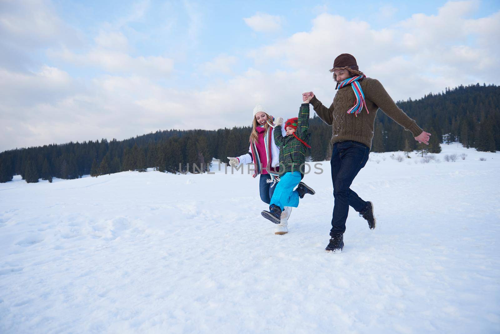 happy young  family playing in fresh snow  at beautiful sunny winter day outdoor in nature