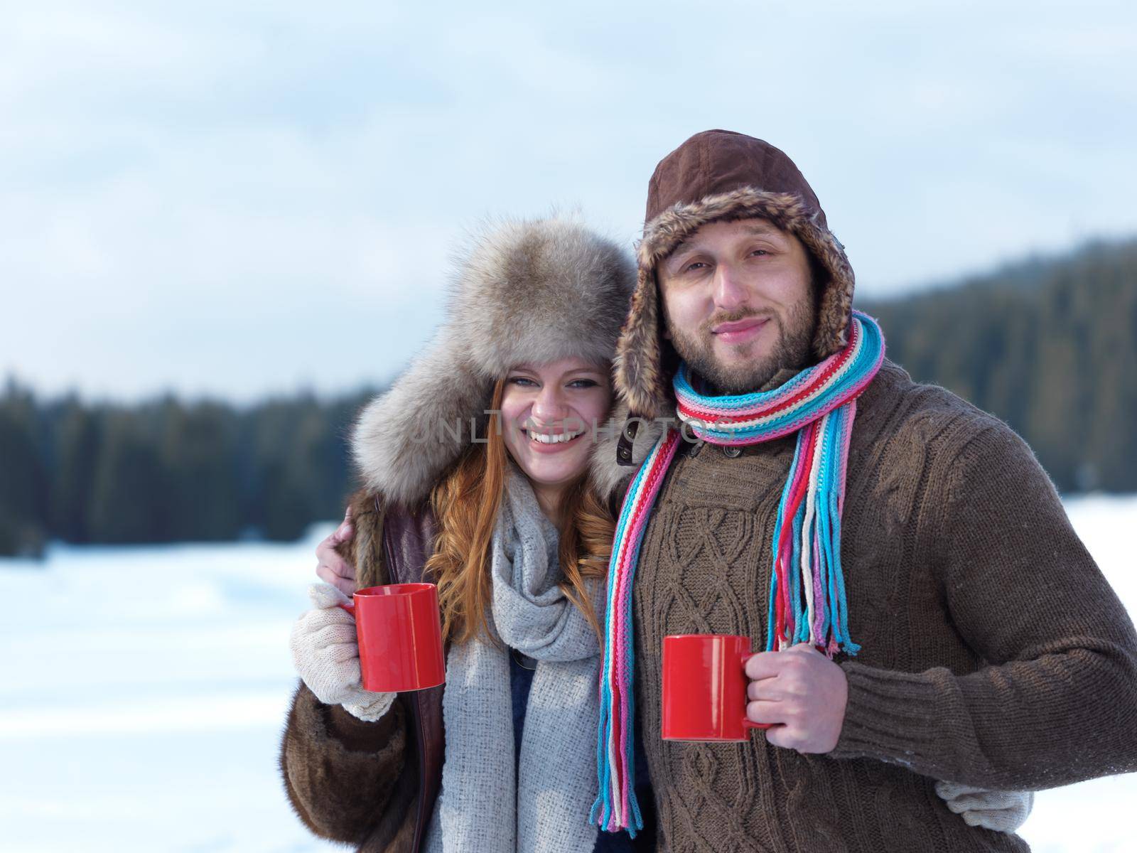 happy young couple drink warm tea at winter by dotshock