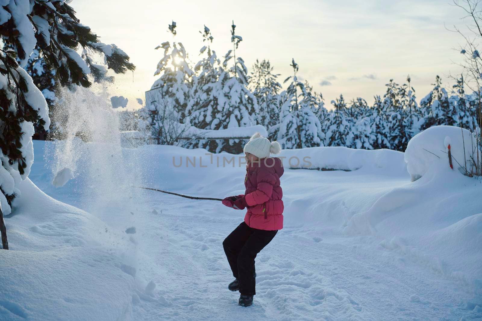 little girl having fun  throwing fresh snow at beautiful sunny winter day