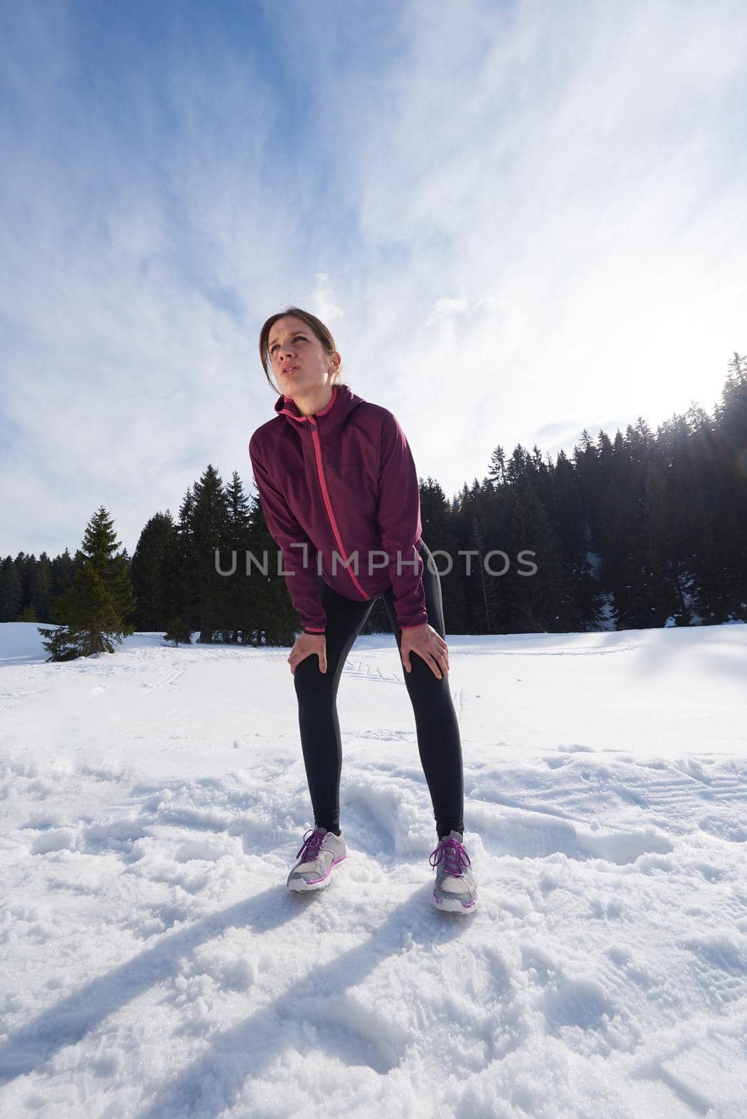 yougn woman jogging outdoor on snow in forest, healthy winter lifestyle and recreation