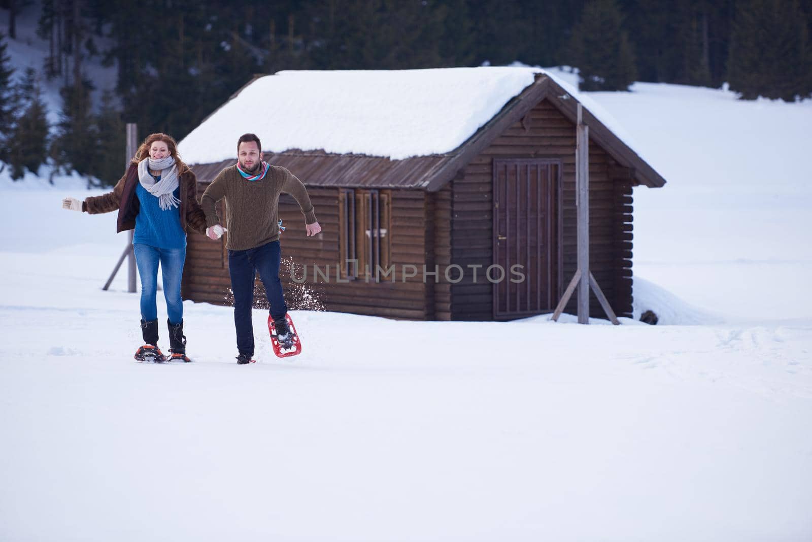 couple having fun and walking in snow shoes by dotshock