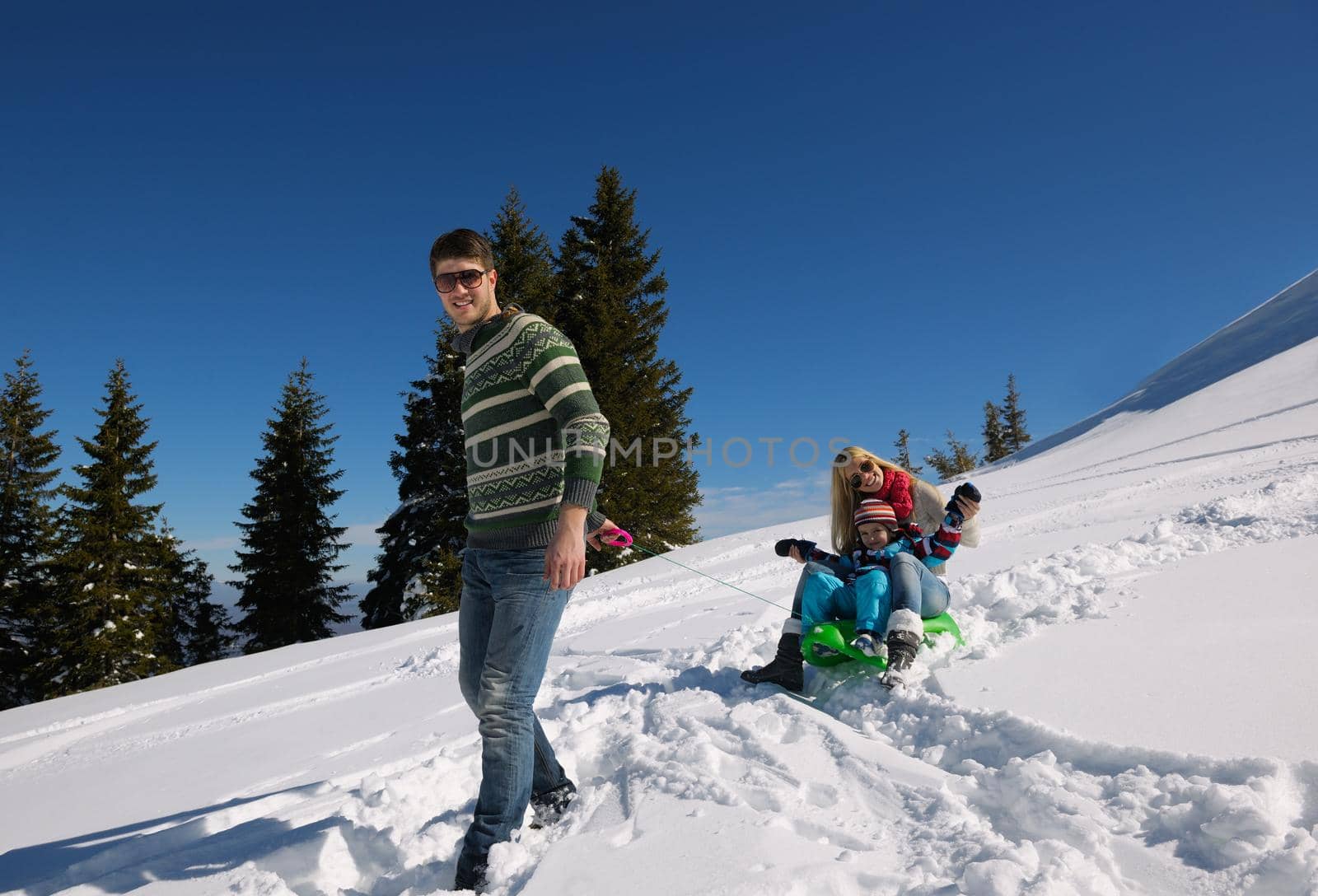 Winter season. Happy family having fun on fresh snow on vacation.