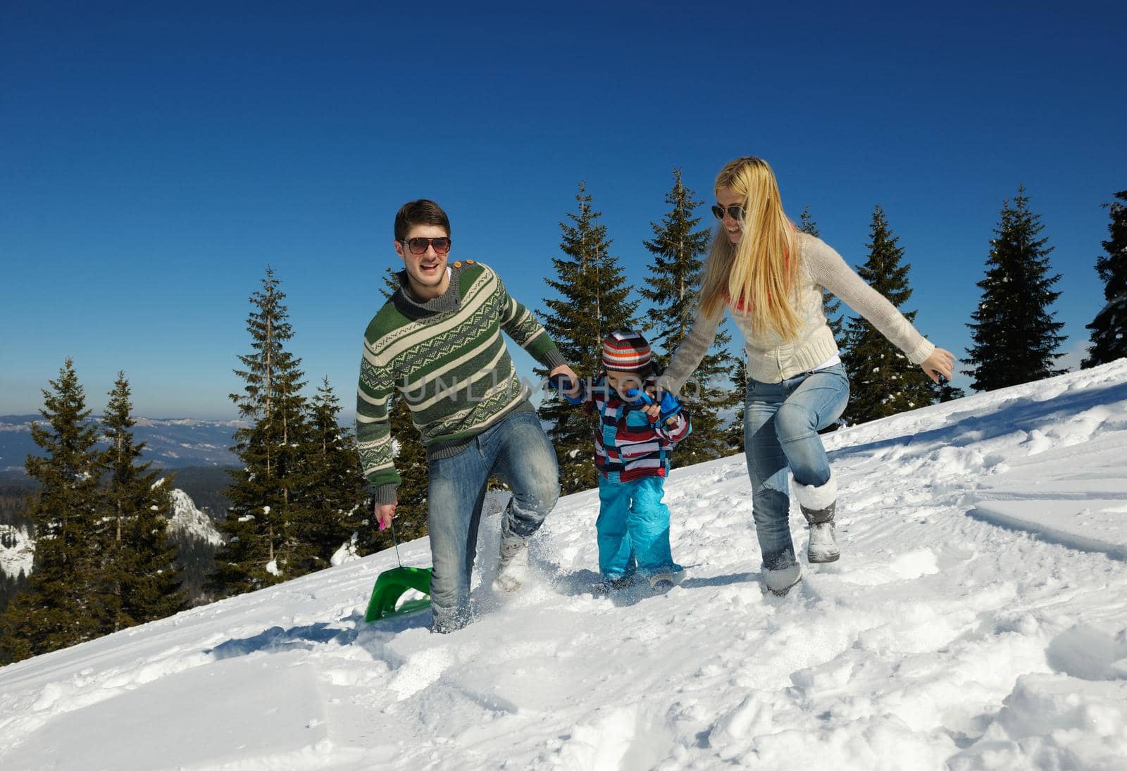 Winter season. Happy family having fun on fresh snow on vacation.