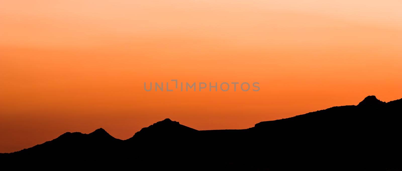 Background from a beautiful colorful sunset with the silhouette of the mountains by Olayola