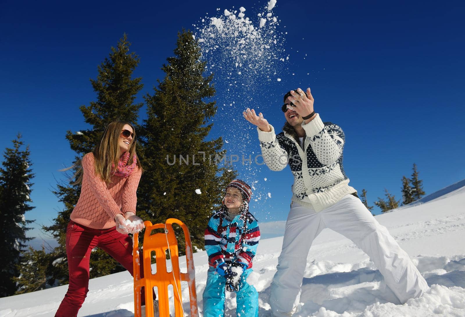 Winter season. Happy family having fun on fresh snow on vacation.