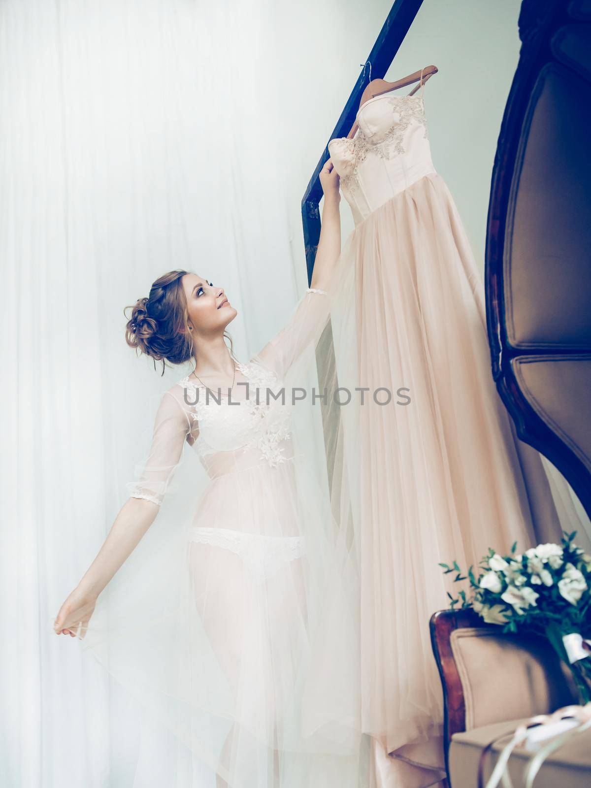 happy girl choosing wedding dress in wedding salon . photo with copy space