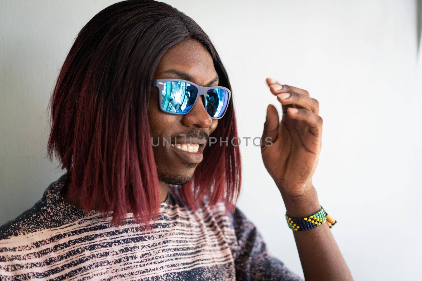 Funny black boy with long hair and sunglasses laughing