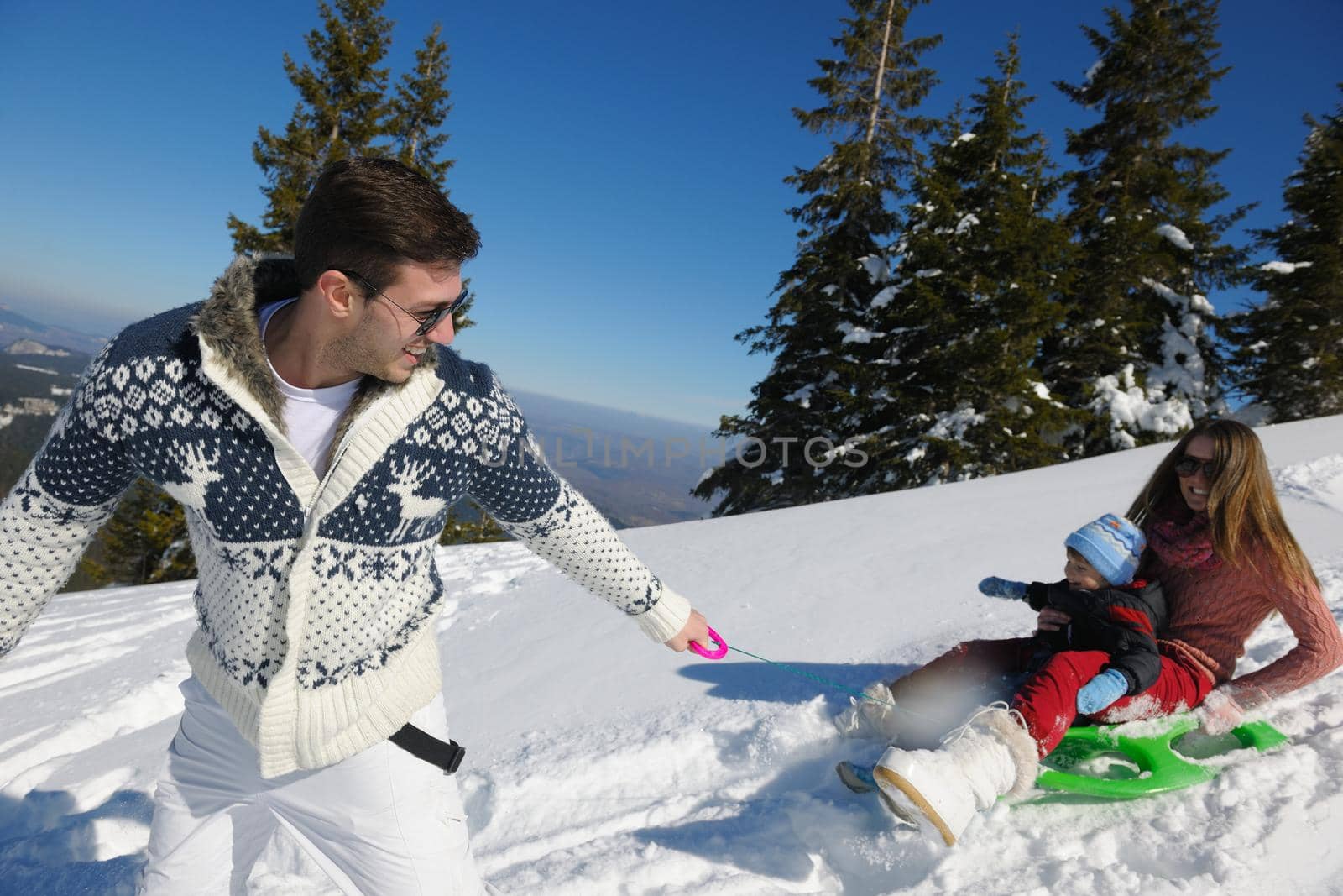 Winter season. Happy family having fun on fresh snow on vacation.