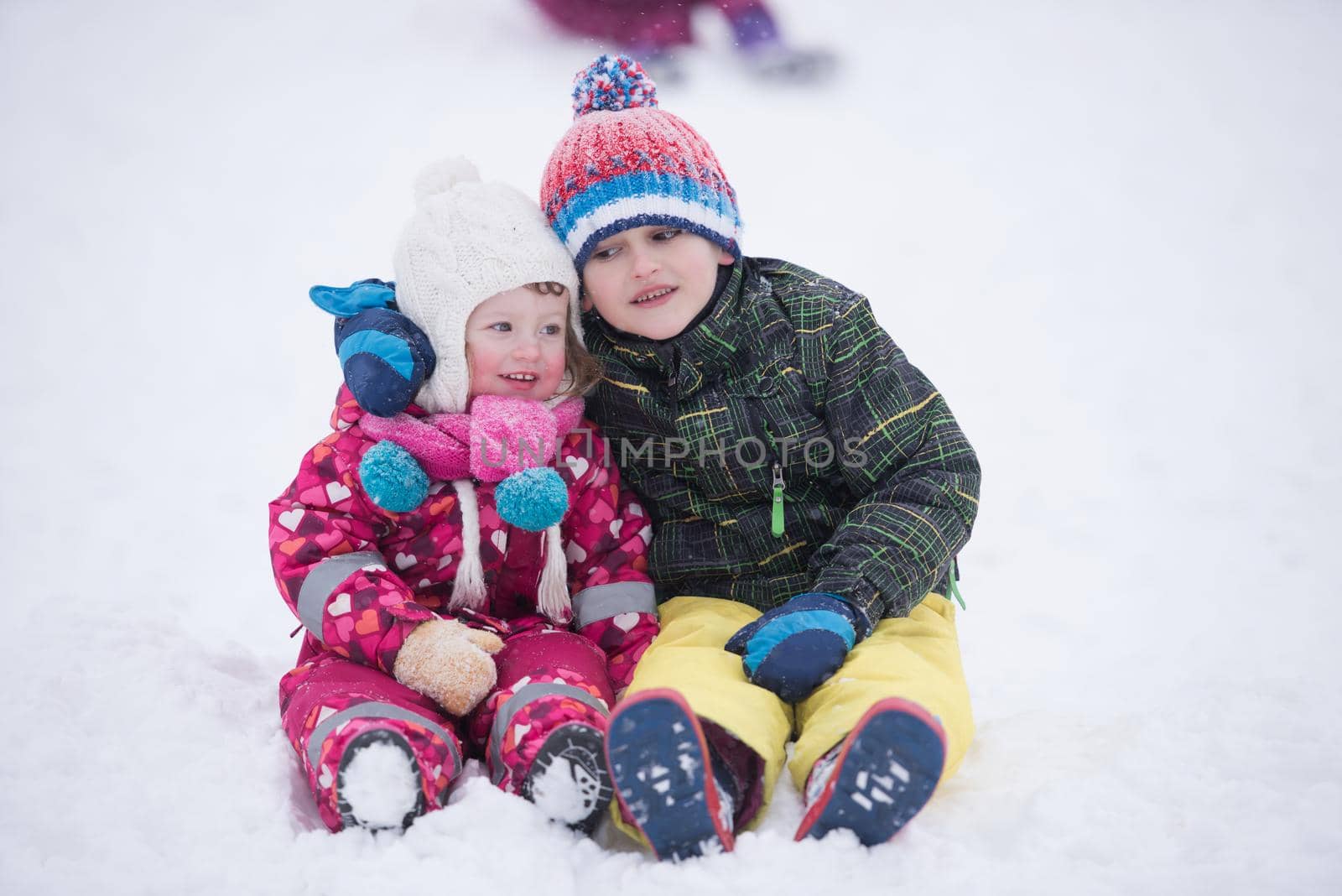 group of children having fun and play together in fresh snow on winter vacation