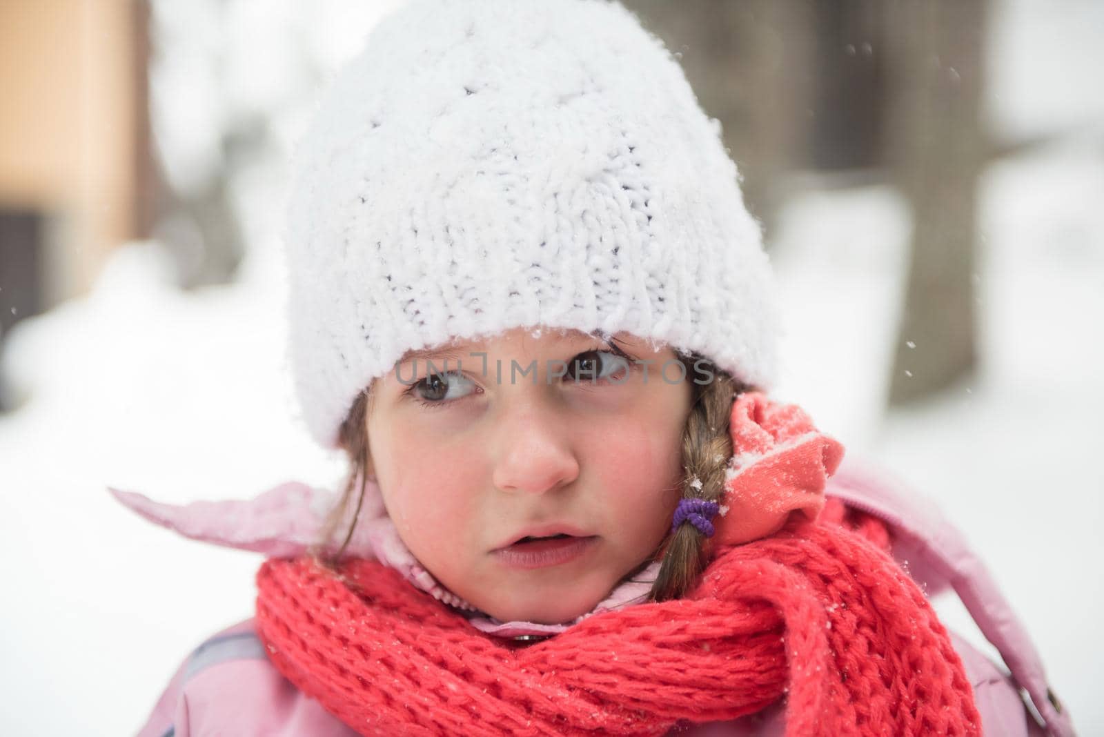 portrait of happy smiling little girl child outdoors having fun and playing on snowy winter day