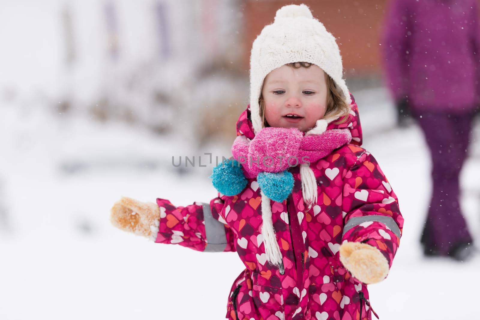 portrait of happy smiling little girl child outdoors having fun and playing on snowy winter day