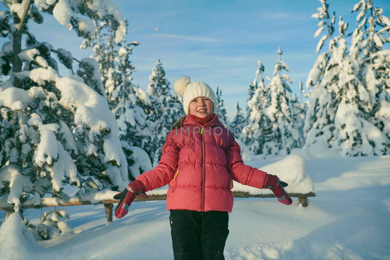 girl throwing fresh snow at beautiful sunny winter day by dotshock